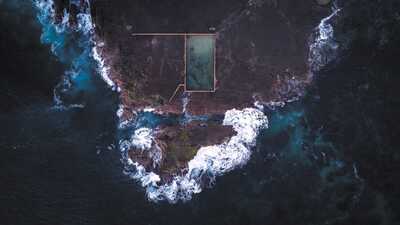 cached/dharmx_walls/aerial/a_swimming_pool_on_a_rocky_island.jpg