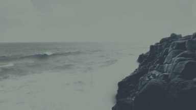 cached/dharmx_walls/apeiros/a_person_standing_on_a_rocky_cliff_by_the_ocean.png