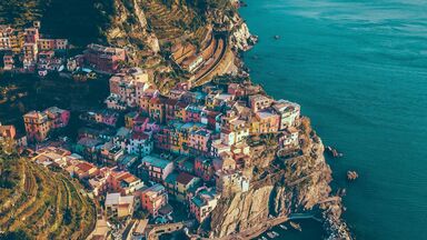 cached/dharmx_walls/architecture/a_colorful_buildings_on_a_cliff_by_the_water.jpg