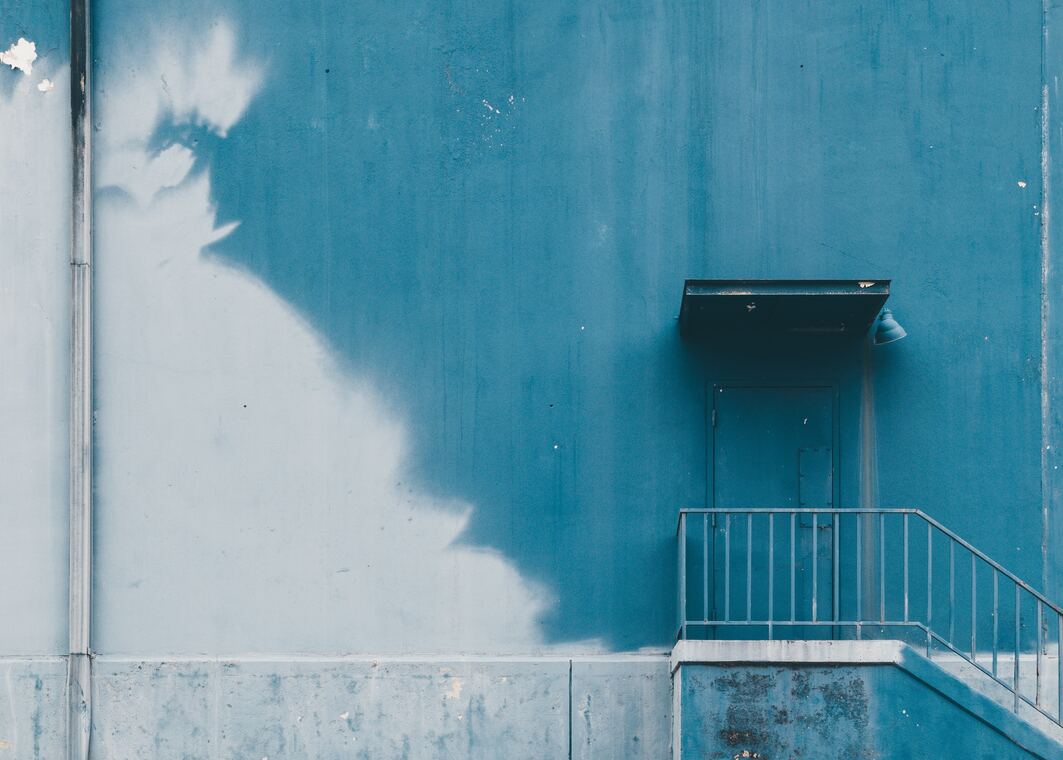cached/dharmx_walls/calm/a_blue_wall_with_a_balcony_and_a_door.jpg