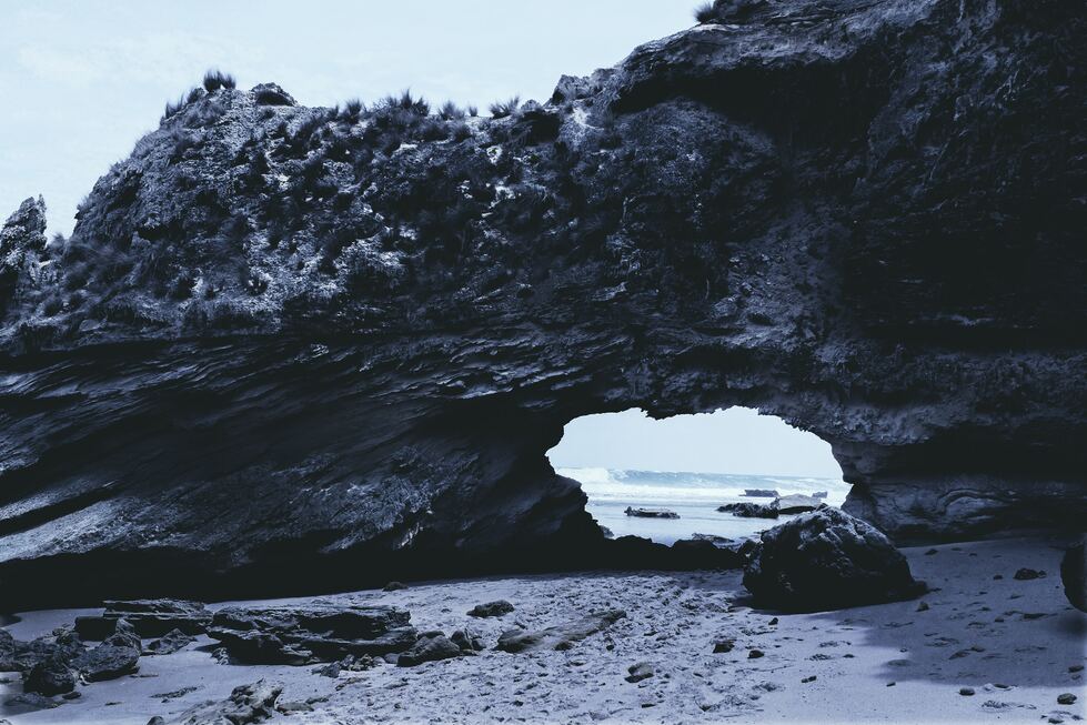 cached/dharmx_walls/calm/a_rock_formation_with_a_hole_in_the_middle.jpg