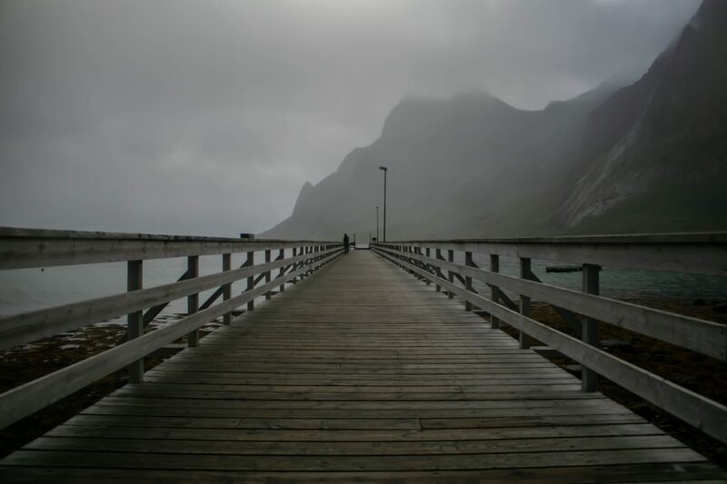 cached/dharmx_walls/calm/a_wooden_bridge_with_railings_and_a_person_walking_on_it.jpg