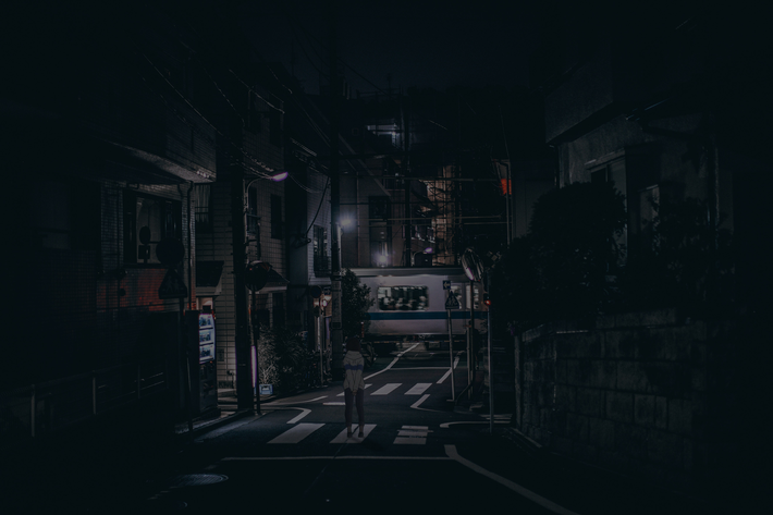 cached/dharmx_walls/chillop/a_person_standing_on_a_street_at_night.png