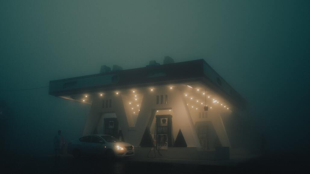 cached/dharmx_walls/dreamcore/a_gas_station_with_lights_on_the_front_and_a_car_parked_in_the_front.jpg