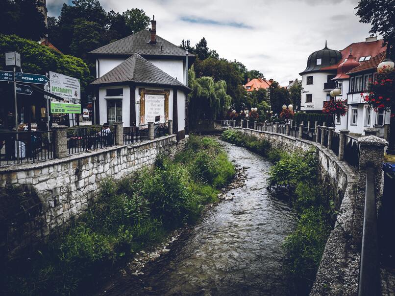 cached/dharmx_walls/dreamcore/a_river_running_through_a_small_town.jpg