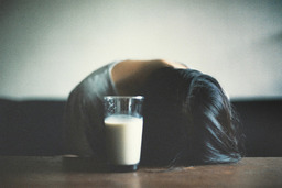 cached/dharmx_walls/girl/a_woman_lying_on_the_floor_with_her_head_on_a_glass_of_milk.jpg