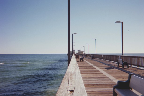 cached/dharmx_walls/girl/a_wooden_walkway_with_benches_and_a_body_of_water.jpg