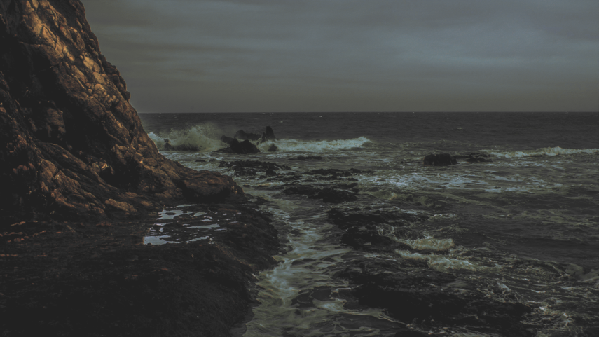 cached/dharmx_walls/gruvbox/a_rocky_beach_with_waves_crashing_on_the_shore.png