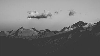 cached/dharmx_walls/monochrome/a_moon_in_the_sky_above_mountains.jpg