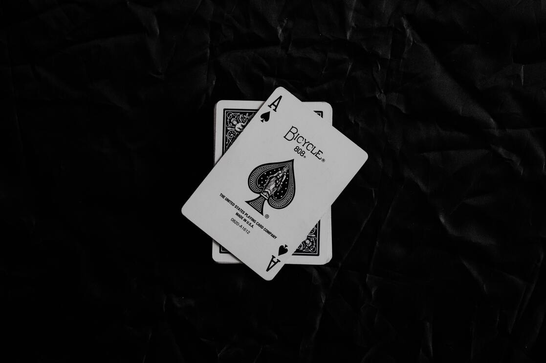 cached/dharmx_walls/monochrome/a_pair_of_playing_cards_on_a_black_surface.jpg