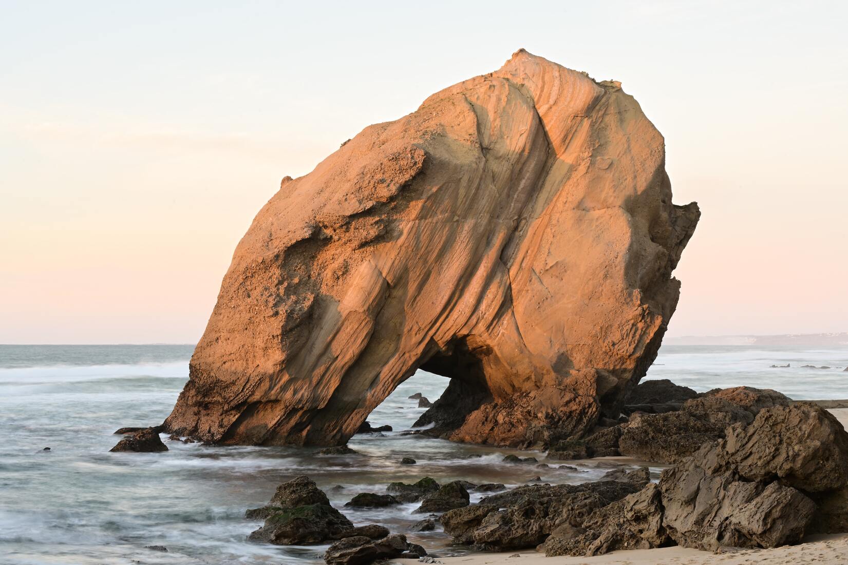 cached/dharmx_walls/mountain/a_large_rock_formation_on_a_beach.jpg