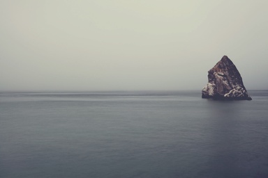 cached/dharmx_walls/mountain/a_large_rock_in_the_middle_of_a_body_of_water.jpg