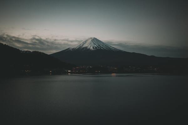 cached/dharmx_walls/mountain/a_mountain_with_snow_on_top_and_a_body_of_water.jpg