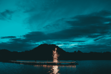 cached/dharmx_walls/nature/a_body_of_water_with_a_lit_up_tower_in_the_middle.png