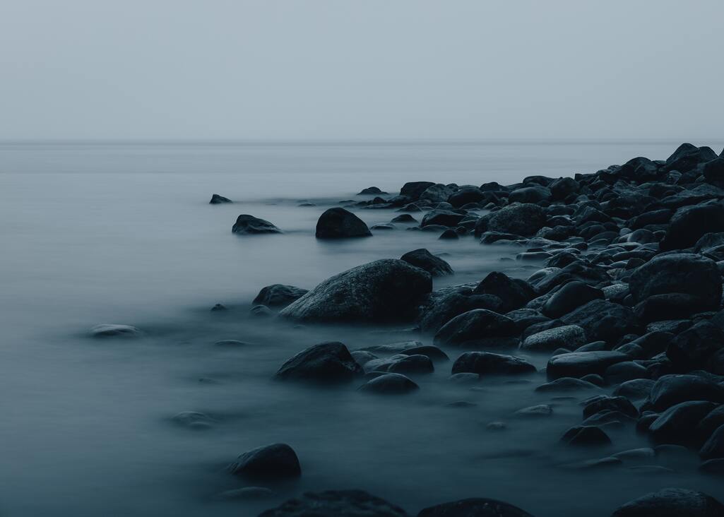 cached/dharmx_walls/nature/a_rocky_beach_with_water_in_the_background.jpg