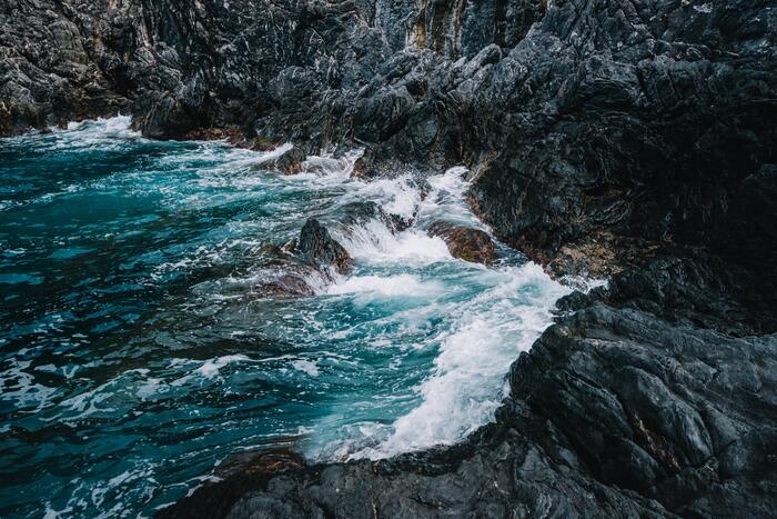 cached/dharmx_walls/nature/a_rocky_shore_with_waves_crashing_on_rocks.jpg