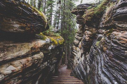 cached/dharmx_walls/nature/a_stairs_leading_to_a_rocky_canyon_with_Flume_Gorge_in_the_background.jpg