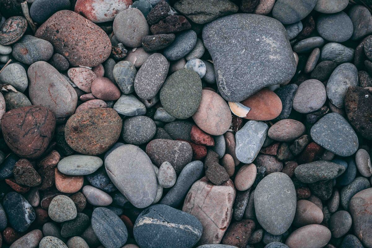 cached/dharmx_walls/unsorted/a_group_of_rocks_on_a_beach.jpg