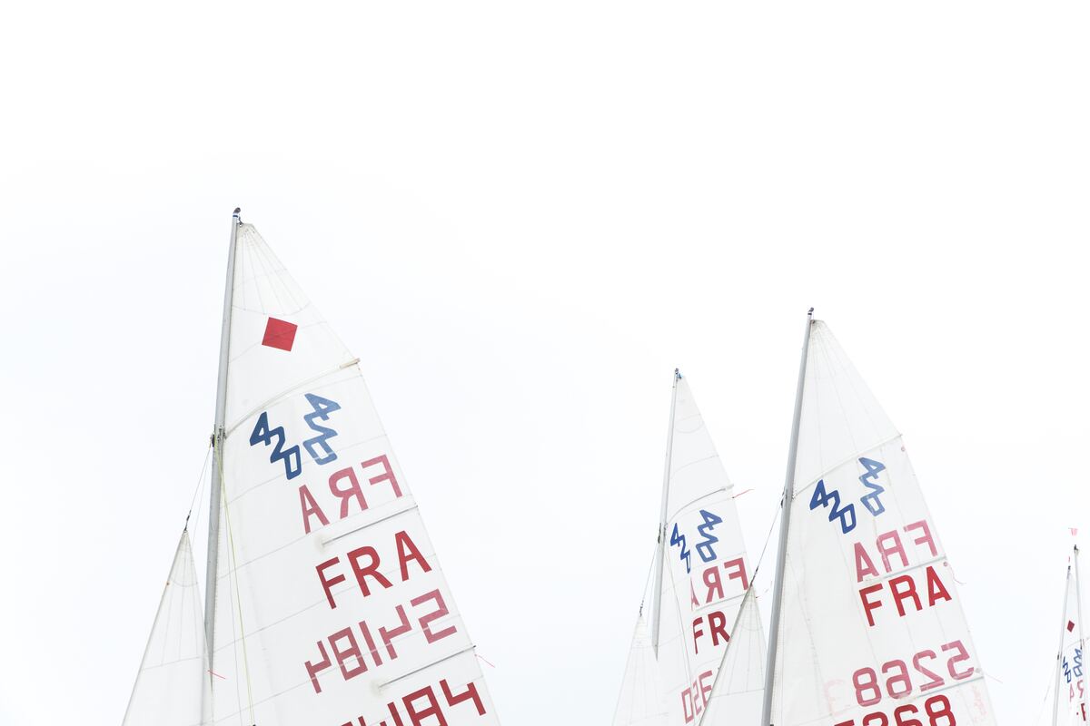 cached/dharmx_walls/unsorted/a_group_of_sailboats_with_red_and_blue_writing.jpg