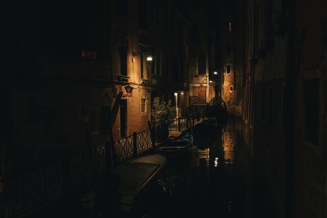 cached/dharmx_walls/unsorted/a_narrow_canal_with_boats_and_buildings_at_night.jpg