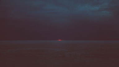 cached/dharmx_walls/wave/a_sunset_over_a_body_of_water_with_Marfa_lights_in_the_background.png